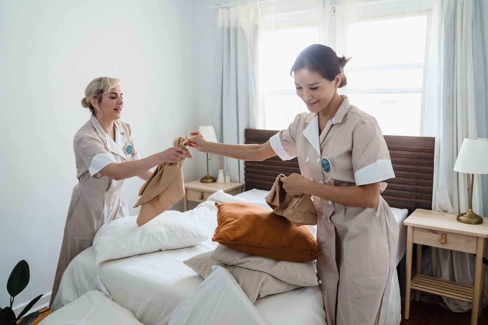 Two Breeza crew members making a bed